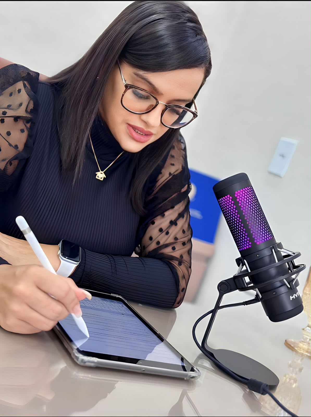 Ana Paula Ribeiro, advogada, escrevendo no tablet ao lado do microfone de gravação